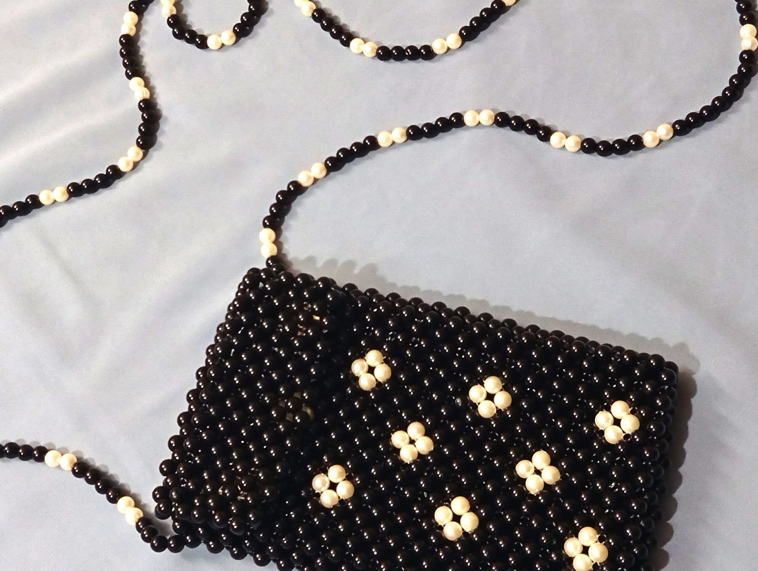 Handmade beaded black crossbody pouch with white floral bead design
