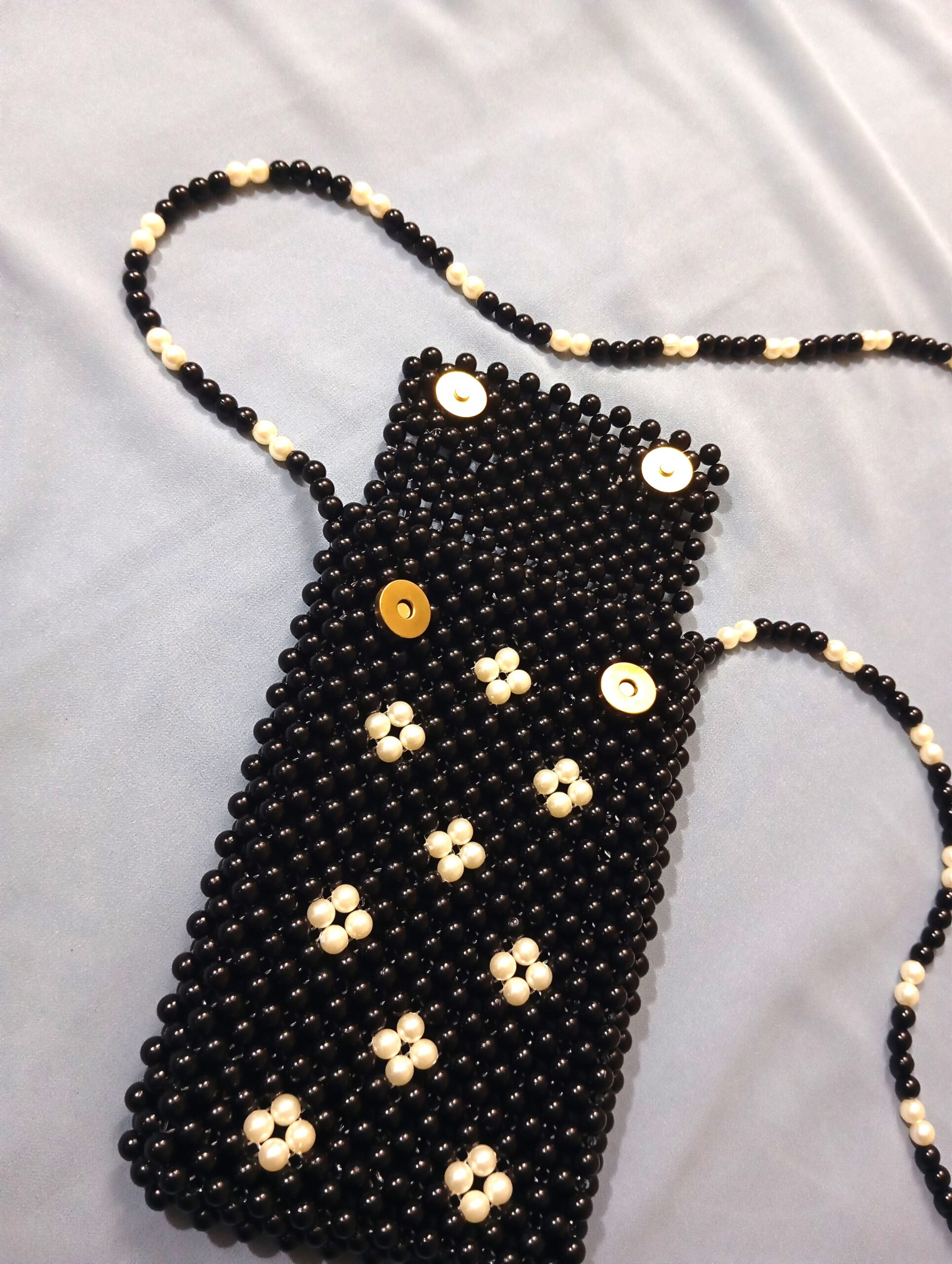 Handmade beaded black crossbody pouch with white floral bead design